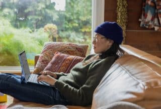 a person sitting at a table using a laptop